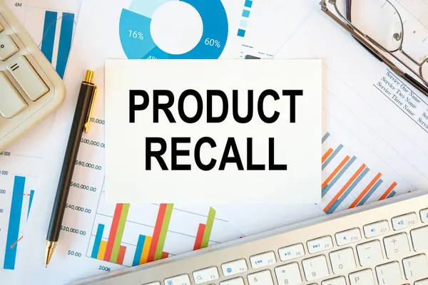 PRODUCT RECALL is written in a document on the office desk with office accessories, keyboard and diagram