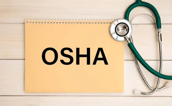 Notepad with the inscription OSHA - Occupational Safety and Health Administration, and stethoscope. Medical concept.