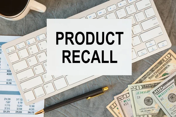 PRODUCT RECALL is written in a document on the office desk with office accessories, keyboard and diagram