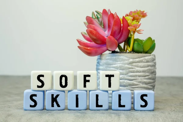 Soft cubes with the abbreviation Soft Skills with a flower on a white background