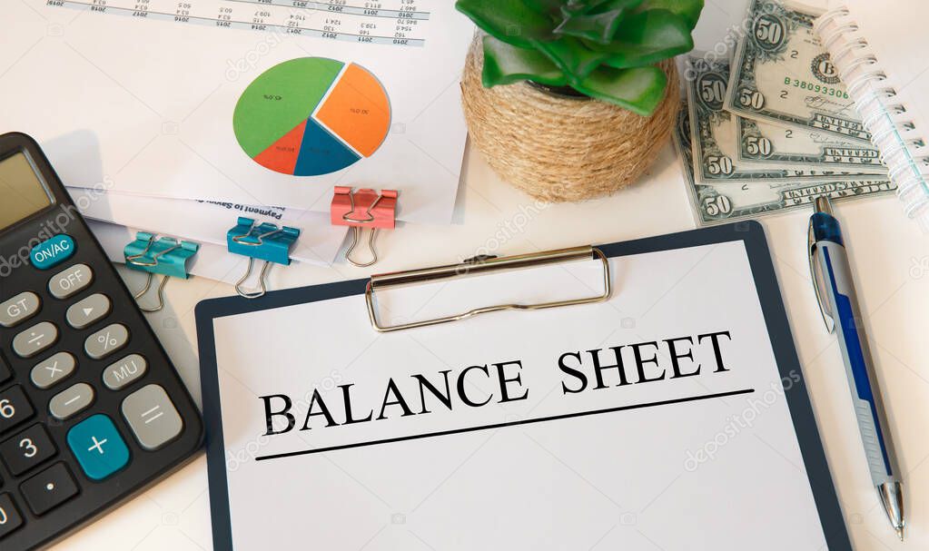 Paper with BALANCE SHEET on the office table, calculator and money