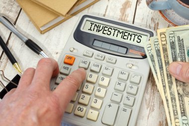 Hesap makinesinde InveSTMENTS kelimesi. İş ve vergi kavramı.