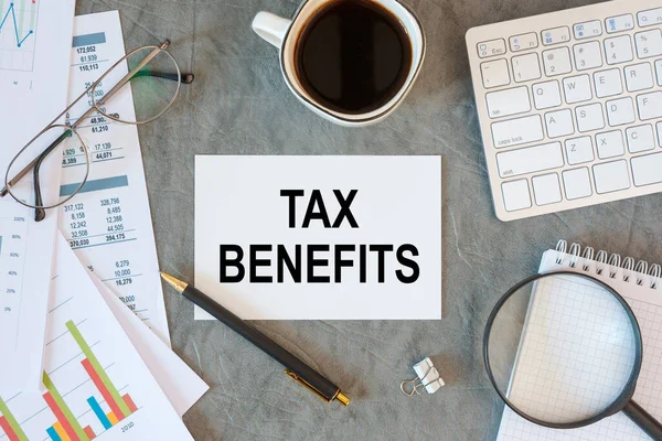 TAX BENEFITS is written in a document on the office desk with office accessories, keyboard and diagram