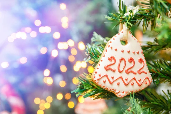 2022年的蜂蜜蛋糕挂在圣诞树和新年灯火上 — 图库照片