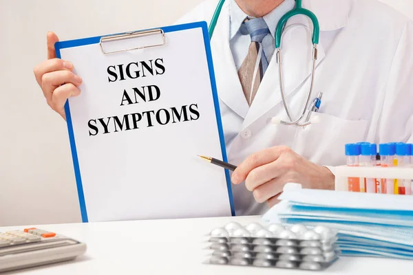 Doctor Holds Paper Inscription Signs Symptoms Stethoscope Pills Table — Foto de Stock