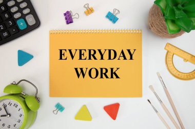 Çalışma her gün bir deftere yazılır. Ofis masasının üzerinde ofis malzemeleriyle birlikte..