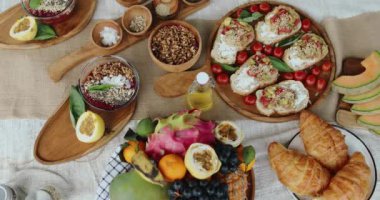 Meyve suyu kasesi bir tabak bruschetta, kruvasan ve meyvenin yanında duruyor.
