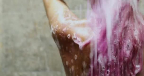 Close up tiro de uma mulher com as costas nuas e lavagem de cabelo rosa no chuveiro — Vídeo de Stock