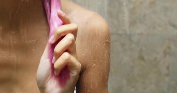 Duşta bir kadın, akan suyun altında parlak pembe saçlarını okşar. — Stok video