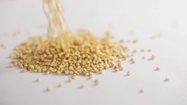 Beyaz bir arkaplanda yuvarlanan beyaz kinoanın yakın plan çekimi bir masada dönüyor