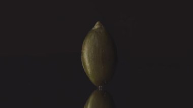 Tek bir kabak kabağı kabuğunun makro görüntüsü hareket eden ışıkla düz duruyor.