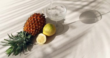 Ananas, limon, palmiye ağacı gölgeleri ve bir bardak soda.