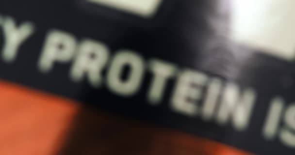 Proteïne, diagonale close-up inscriptie op een zwarte achtergrond met variabele focus — Stockvideo