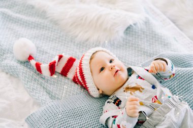 Çocuğun ilk Noel 'i. Noel Baba şapkalı şirin bir çocuk. Yatağa uzan. Yukarıdan manzara. Noel konsepti.