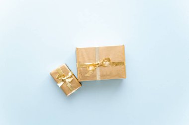 Altın Noel ya da yeni yıl arkaplanı. Altın Noel hediyelerinin sade kompozisyonu. Düz çizgi, mesaj iletmek için boş alan. Noel konsepti