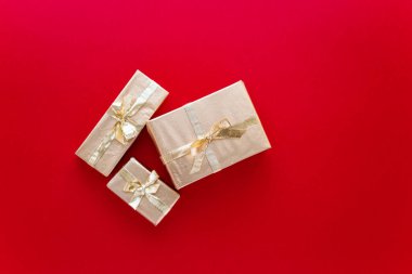 Kırmızı Noel ya da yeni yıl arkaplanı. Altın Noel hediyelerinin sade kompozisyonu. Düz çizgi, mesaj iletmek için boş alan. Noel konsepti