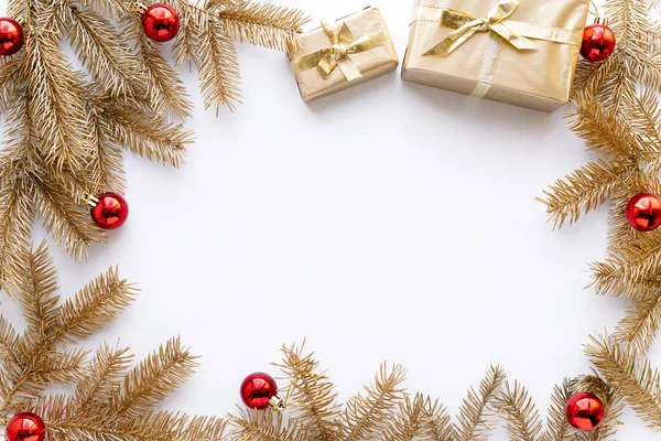 Beyaz Noel veya yeni yıl arkaplanı, altın Noel hediyelerinin ve altın köknar dallarının sade kompozisyonu, düzlük, düzlük, mesajlaşma için boş alan. Noel konsepti.