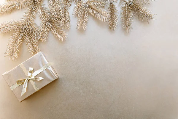 Altın Noel veya yeni yıl arkaplanı, altın Noel hediyelerinin sade kompozisyonu ve altın köknar dalları, düzlük, mesaj atmak için boş alan.