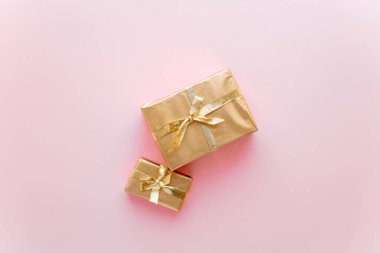 Pembe Noel ya da yeni yıl arkaplanı. Altın Noel hediyelerinin sade kompozisyonu. Düz çizgi, mesaj iletmek için boş alan. Noel konsepti