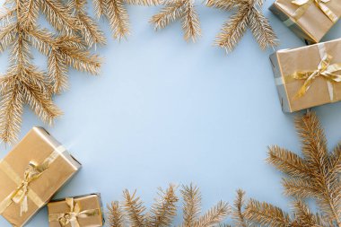 Mavi Noel ya da yeni yıl geçmişi, altın Noel hediyelerinin ve altın köknar dallarının sade kompozisyonu, düzlük, düzlük, mesajlaşma için boş alan. Noel konsepti..