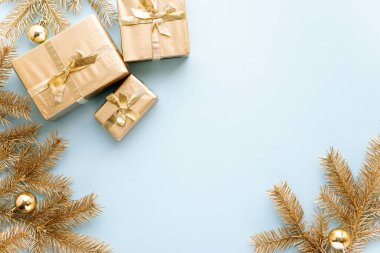 Mavi Noel ya da yeni yıl geçmişi, Noel hediyelerinin sade kompozisyonu ve noel oyuncaklarıyla altın köknar dalları, Flatlay, mesajlaşmak için boş alan. Noel konsepti..