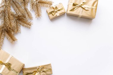 Beyaz Noel veya yeni yıl arkaplanı, altın Noel hediyelerinin ve altın köknar dallarının sade kompozisyonu, düzlük, düzlük, mesajlaşma için boş alan. Noel konsepti.