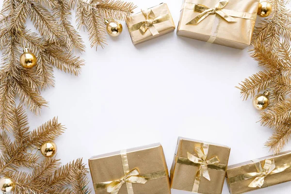 Fehér karácsony vagy újévi háttér, egyszerű összetétele arany karácsonyi ajándékok és arany fenyő ágak karácsonyi játékok, Flatlay, üres tér üdvözlő text.christmas koncepció. Jogdíjmentes Stock Képek