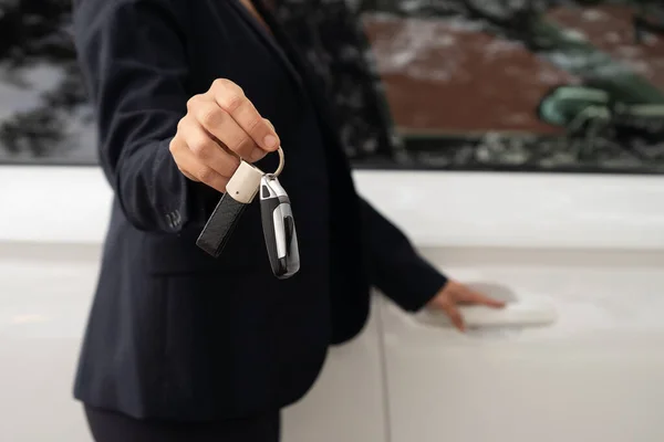 hand of a car saleswoman handing over keys