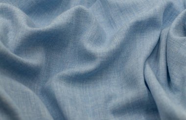 Blue linen texture. Light blue fabric surface with soft folds. Linen knitted fabric. Linen fabric. Light blue linen background. Blue fabric texture background. Textile material for design.