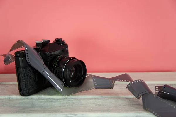 camera and photo film on a white surface