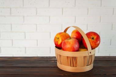 Bir ahşap yüzeyde bir sepet elma