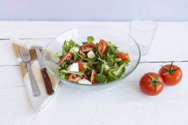 Beyaz ahşap arka planda domatesli vejetaryen salatası