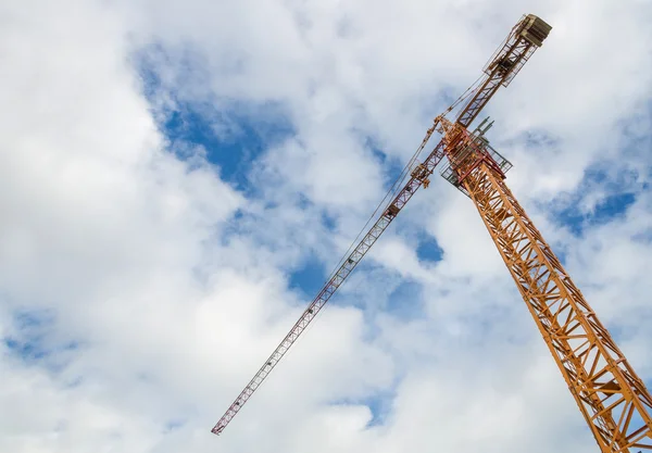 Guindaste e trabalhadores em canteiro de obras com fundo céu azul — Fotografia de Stock