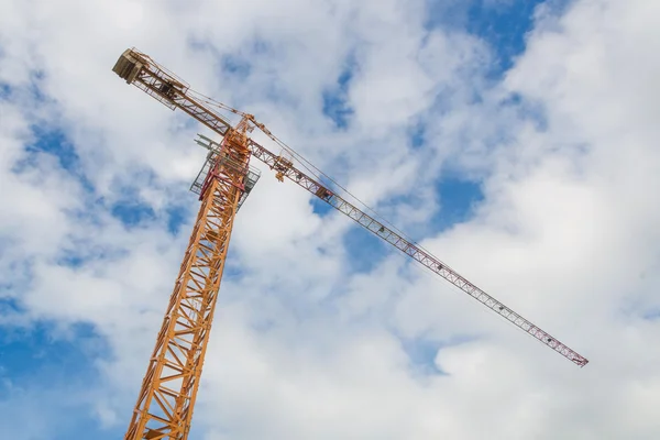 Kran og arbejdere på byggepladsen med blå himmel baggrund - Stock-foto
