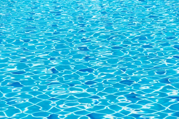 Verschwommenes blaues Schwimmbad mit sonnigen Reflexen — Stockfoto