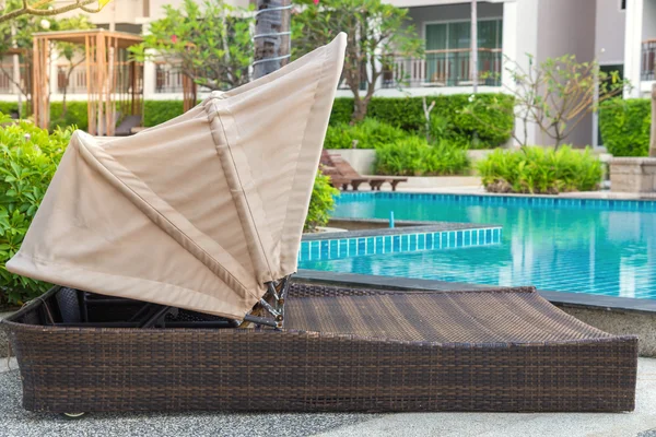 Cama de piscina cerca de la piscina en el complejo tropical —  Fotos de Stock