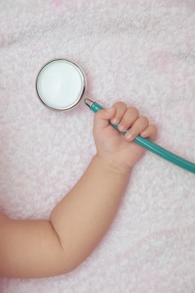 Instrumentos médicos estetoscopio en la mano de la niña — Foto de Stock