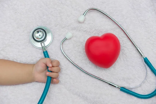 Medical instruments stethoscope in hand of baby girl — Stock Photo, Image