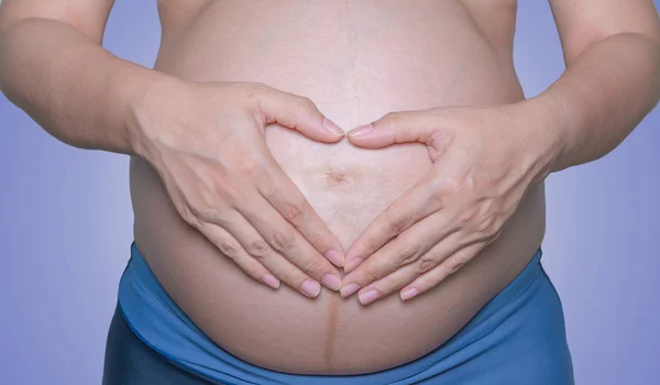 Donna incinta con le mani isolate su sfondo bianco — Foto Stock