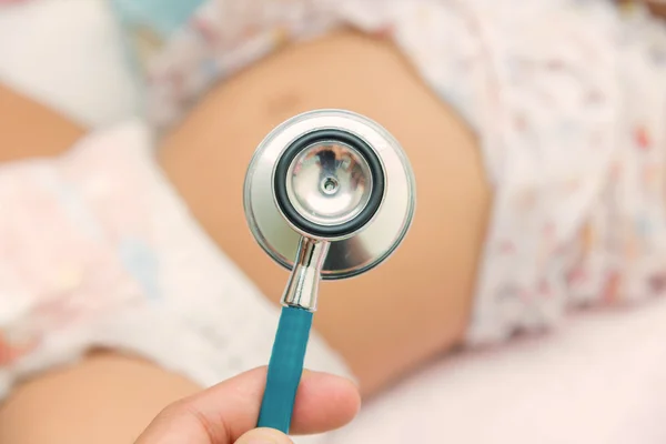 Pediatric doctor exams newborn baby girl with stethoscope in hos — Stock Photo, Image