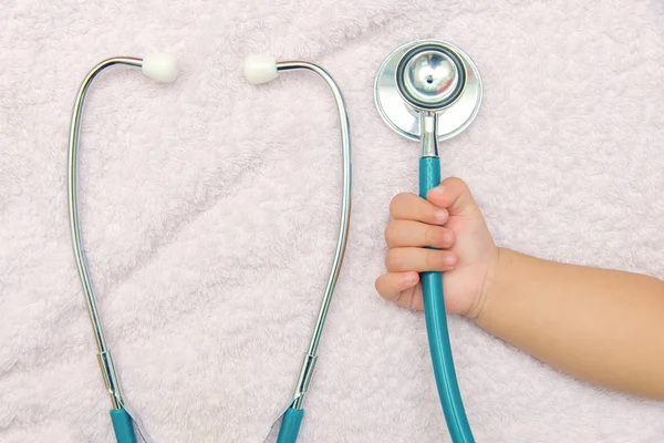 Orvosi műszerek sztetoszkóp baba lány kezét — Stock Fotó