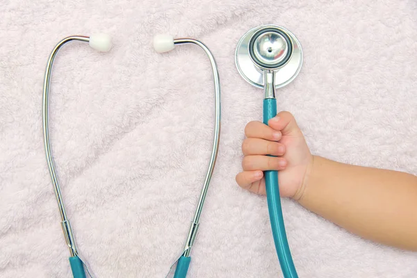 Instrumentos médicos estetoscopio en la mano de la niña — Foto de Stock