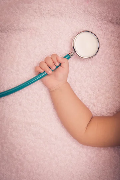 Medical instruments stethoscope in hand of baby girl — Stock Photo, Image