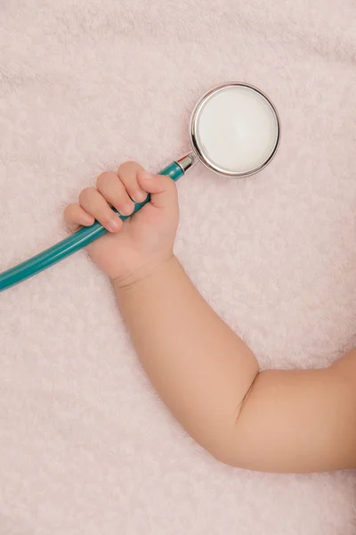 Medical instruments stethoscope in hand of baby girl — Stock Photo, Image