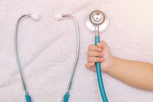 Medische instrumenten stethoscoop in hand van babymeisje — Stockfoto