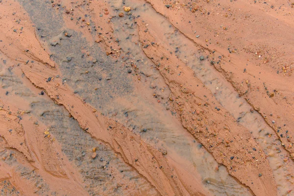 Barro y piedra en el agua a medida que fluye por carretera en el día de lluvia —  Fotos de Stock