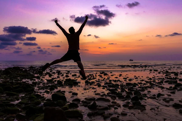 Man Happy jump with his hands up during sunset at the beach — Stock Photo, Image