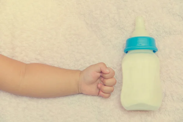 Butelka mleka i ręka noworodka dziewczynka — Zdjęcie stockowe
