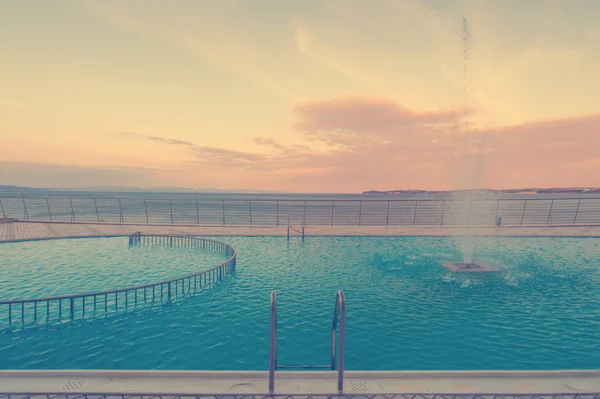 Piscine de luxe en face de la mer au coucher du soleil — Photo