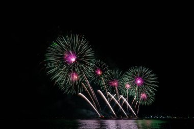 Geceleyin çeşitli renklerde renkli havai fişekler ve kutlama ve yıldönümü konsepti..